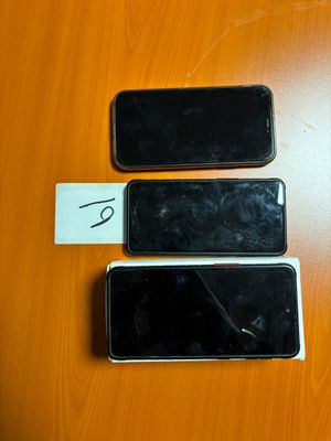 trois téléphones portables posés les uns à côté des autres sur une table en bois