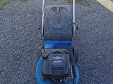 an image of a blue lawn mower parked on the side of the road