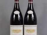 two bottles of wine sitting on top of a table next to each other
