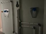 a bathroom with a toilet and a wall mounted water dispenser
