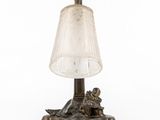 an old fashioned lamp with a glass shade on top of it