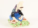 a figurine of a woman sitting on a rock