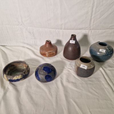 five different vases sitting on a white sheet
