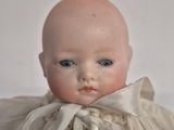 a small doll with a white dress on it ' s head