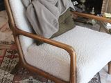 a chair with a blanket on it in front of a fire place