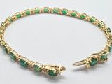 un gros plan d'un bracelet orné de pierres vertes sur un fond blanc