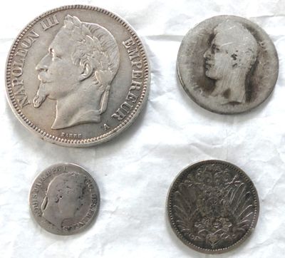 Plusieurs pièces de monnaie sont posées sur un morceau de papier, sur une table.