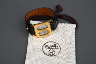une ceinture en cuir avec une boucle dorée et une pochette blanche