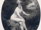 an old picture of a naked woman sitting on a rock
