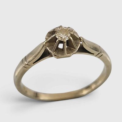 gros plan d'une bague en or avec un diamant au centre