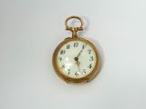 a small gold pocket watch on a white surface