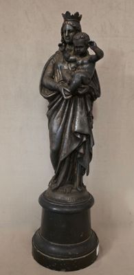 statue en bronze représentant une femme tenant un enfant dans ses bras, posée sur un socle
