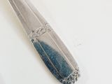 a silver spoon and a knife on a white table