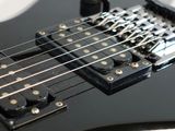 a close up of a black electric guitar on a table