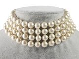 a close up of a necklace with pearls on a mannequin