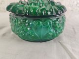 a green glass bowl with a lid on a table
