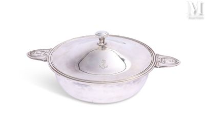 une casserole argentée avec un couvercle, posée sur un plan de travail blanc