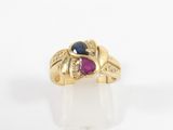 a close up of a gold ring with a blue and pink stone