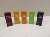 four bottles of perfume sitting on top of a white table