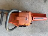 a close up of a chainsaw sitting on a concrete floor