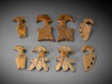 six pieces of carved wood are arranged on a gray surface