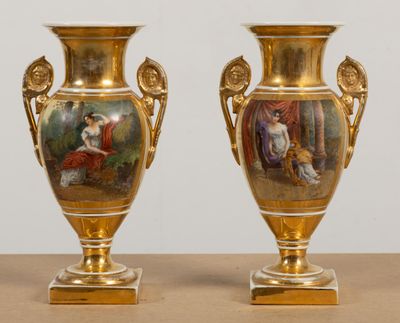 deux vases en or ornés de peintures, posés sur une table