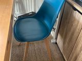 a blue chair that is sitting in front of a desk