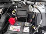 a car engine with its hood open and a car battery in it