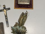 a cross, a plaque, and other religious items on the wall