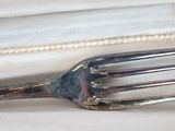 a fork that is laying on top of a white cloth