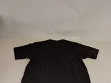a black shirt sitting on top of a bed next to a pillow