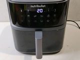 a black air fryer sitting on a white table