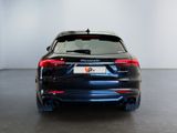 the rear end of a black car in a white room
