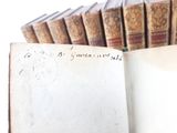 an open book with writing on it sitting in front of a row of books