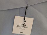 the label is attached to a light blue shirt with a black tie