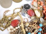 a pile of assorted jewelry on a white surface