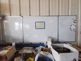 un tableau blanc au milieu d'une pièce remplie de cartons