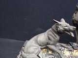 statue of a man and a dog sitting on a marble base