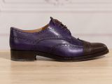 the purple shoes are on a wooden table with a white wall in the background