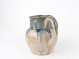 un vase bleu et blanc posé sur une surface blanche