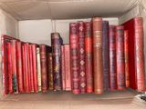 many books in a cardboard box on a shelf