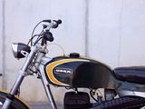 a black and yellow motorcycle parked in front of a white wall