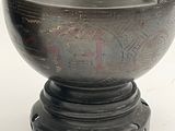 a bronze vase with a bird on top of it