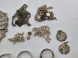 a lot of silver jewelry on a white table