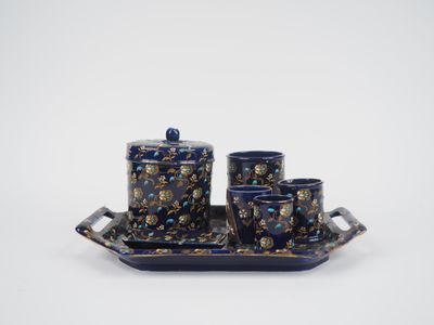 un plateau bleu sur lequel se trouvent trois tasses et une soucoupe