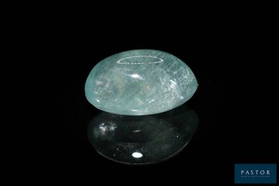 une image représentant une pierre de jade verte posée sur une surface noire