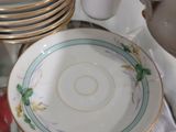 de nombreuses assiettes et tasses posées sur une table en verre, avec une théière