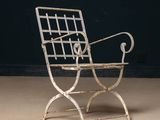 an old iron chair sitting on top of a cement floor