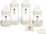 three baby bottles with a pacifier and a dummy on a white background