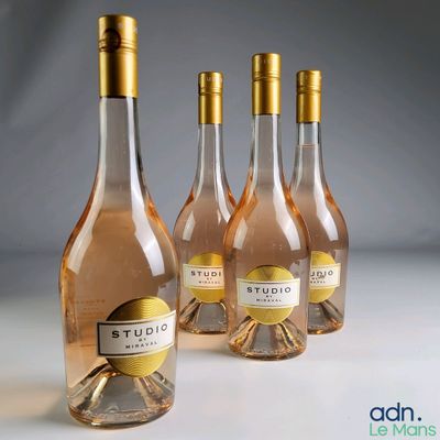 Trois bouteilles de vin rosé sont alignées sur une table